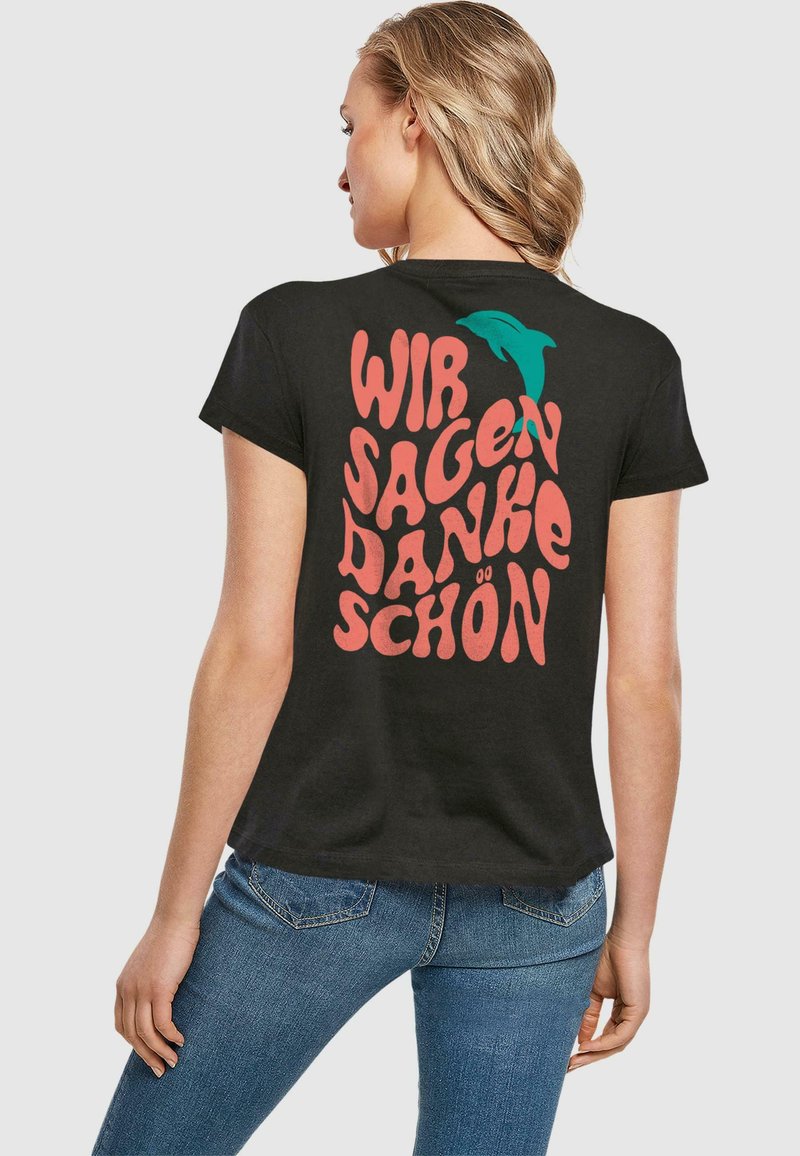 Čierne bavlnené tričko s retro štýlovým ružovým textom "WIR SAGEN DANKE SCHÖN" a grafikou teal delfína na zadnej strane. Krátke rukávy.