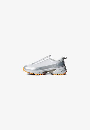 Silver athletic sneaker with a smooth finish, orange rubber sole, and textured accents. Features laces and a loop at the heel for easy wear.
