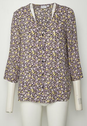 Blusa com estampado botânico, apresentando um fundo preto com pequenas flores amarelas e lavanda, mangas 3/4 e um decote em V com detalhes em botão.