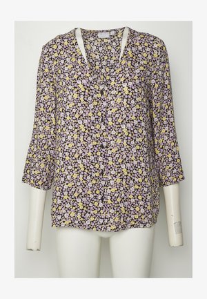 Blusa com estampado botânico, apresentando um fundo preto com pequenas flores amarelas e lavanda, mangas 3/4 e um decote em V com detalhes em botão.