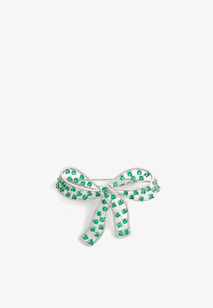 Broche plateada en forma de arco con rhinestones verdes engastados en un diseño de filigrana, que presenta un acabado texturizado y un cierre tradicional de aguja.
