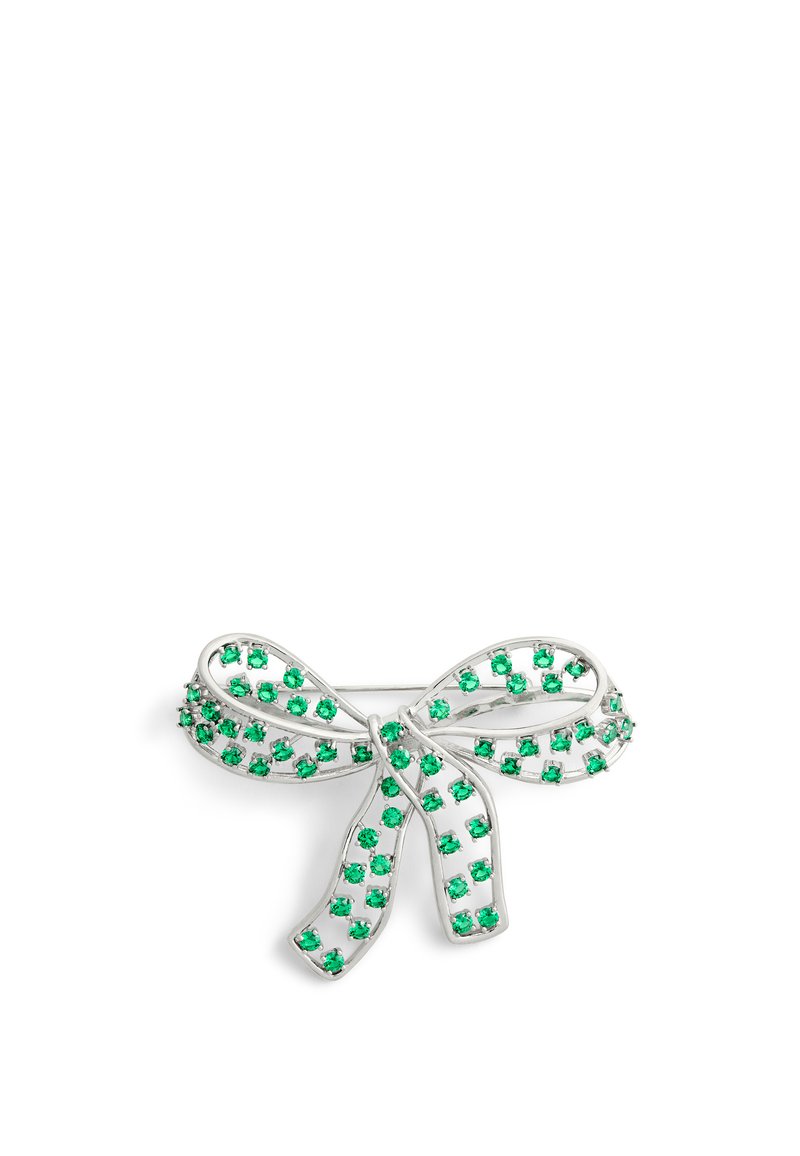 Broche en forme de courbe argentée ornée de strass verts, disposée dans un design en filigrane, avec une finition texturée et un système de fermeture par épingle traditionnel.