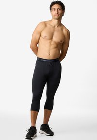 Black compression leggings with a fitted design and elastic waistband featuring the brand "SWEDEMOUNT." Smooth, stretchy material.
