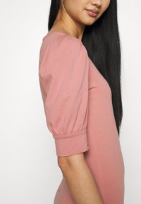 Jasnoróżowa sukienka z bufiastymi rękawami i dopasowanym krojem, z zaokrąglonym dekoltem i gładką fakturą.