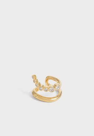 Bague ouverte en or avec deux anneaux, dont l’un présente une rangée courbée de sept pierres précieuses rondes et claires de tailles variées.