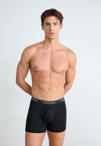 Zwarte katoenen boxershorts met een elastische tailleband waarop het 'Calvin Klein' logo in wit is afgebeeld. Soepele textuur en strakke pasvorm.