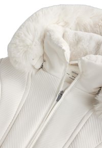 Geacă umplută albă cu un design matlasat, dotată cu o glugă din blană artificială, închideri cu fermoar și căptușeală interioară moale. Aspect ordonat și aerodinamic.