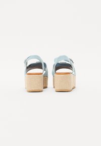 Sandálias de plataforma azul claro com um salto estilo espadrille texturizado, tira para o tornozelo ajustável e um forro interior suave.