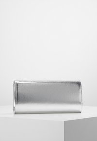 Srebrna metaliczna kopertówka o gładkiej fakturze, prostokątnym kształcie i bezszwowym designie. Nie ma widocznych akcesoriów ani wykończeń.