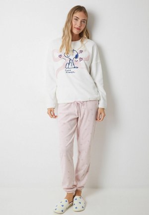 Witte fleece sweatshirt met een olifantafbeelding, gecombineerd met roze fleece broek met kleine sterpatronen en blauwe pantoffels met hartaccenten.