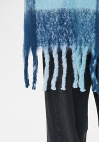 Strikket halstørklæde med en gradient fra dybblå til lyseblå nuancer, med frynser i enderne og en blød, tekstureret finish.