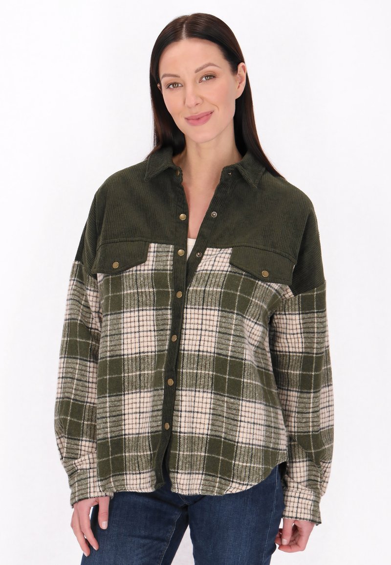 Camisa a cuadros verde y crema con cuello de botón, dos bolsillos en el pecho y textura de pana. Presenta botones de presión dorados y mangas largas.