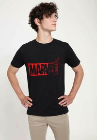 Black cotton T-shirt featuring a large red "MARVEL" graphic with a splatter effect on the front. Short sleeves and a crew neck design.