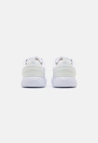 Zapatillas deportivas blancas con una parte superior de malla texturizada, cuello acolchado y suela de goma en contraste. Presenta una pestaña en el talón para facilitar el calzado.
