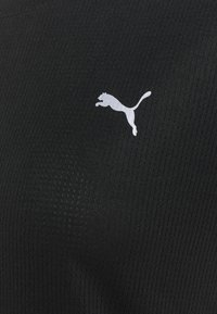Crna sportska tkanina s rebrastom teksturom sadrži bijeli Puma logo skakuće predatori postavljen lijevo.
