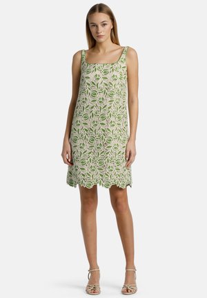Kantjurk met een vierkante halslijn, versierd met groene bladenpatronen op een crèmekleurige achtergrond, met een geschulpte zoom en brede schouderbanden.