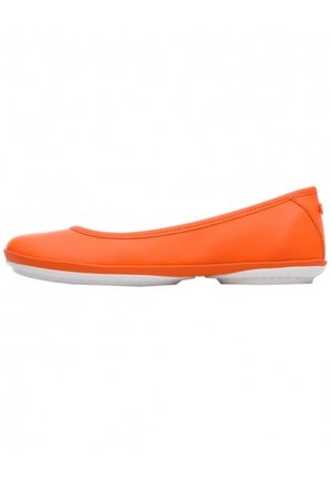 Chaussure de ballet plate orange vif avec bout rond et semelle blanche, vue de profil sur un fond blanc.