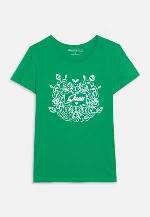 Grünes T-Shirt mit kurzen Ärmeln, weißem Blumenmuster und dem "Guess est. 1981"-Logo mittig auf der Vorderseite.