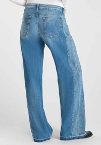 Lichtblauwe denim jeans met een losse fit, met achterzakken en een vervaagde textuur, die het contrast tussen twee denims kleuren tonen.