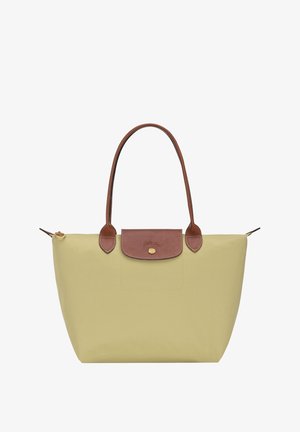 Lime green tote bag made of nylon, featuring a brown leather top flap and handles, with gold zipper and a round logo accent.
