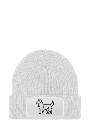 Helle graue Strickmütze mit umgeschlagenem Saum, auf dem eine schwarze Umrandung eines Hundes auf einem weißen rechteckigen Patch aufgedruckt ist. Weiche Textur, schlichtes Design.