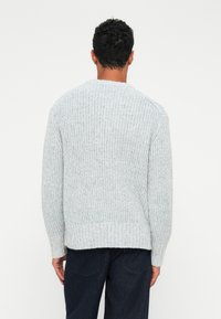 Maglione grigio chiaro lavorato a maglia con texture a coste, scollatura rotonda e maniche lunghe. Caratterizzato da una vestibilità comoda e un orlo dritto sul fondo.