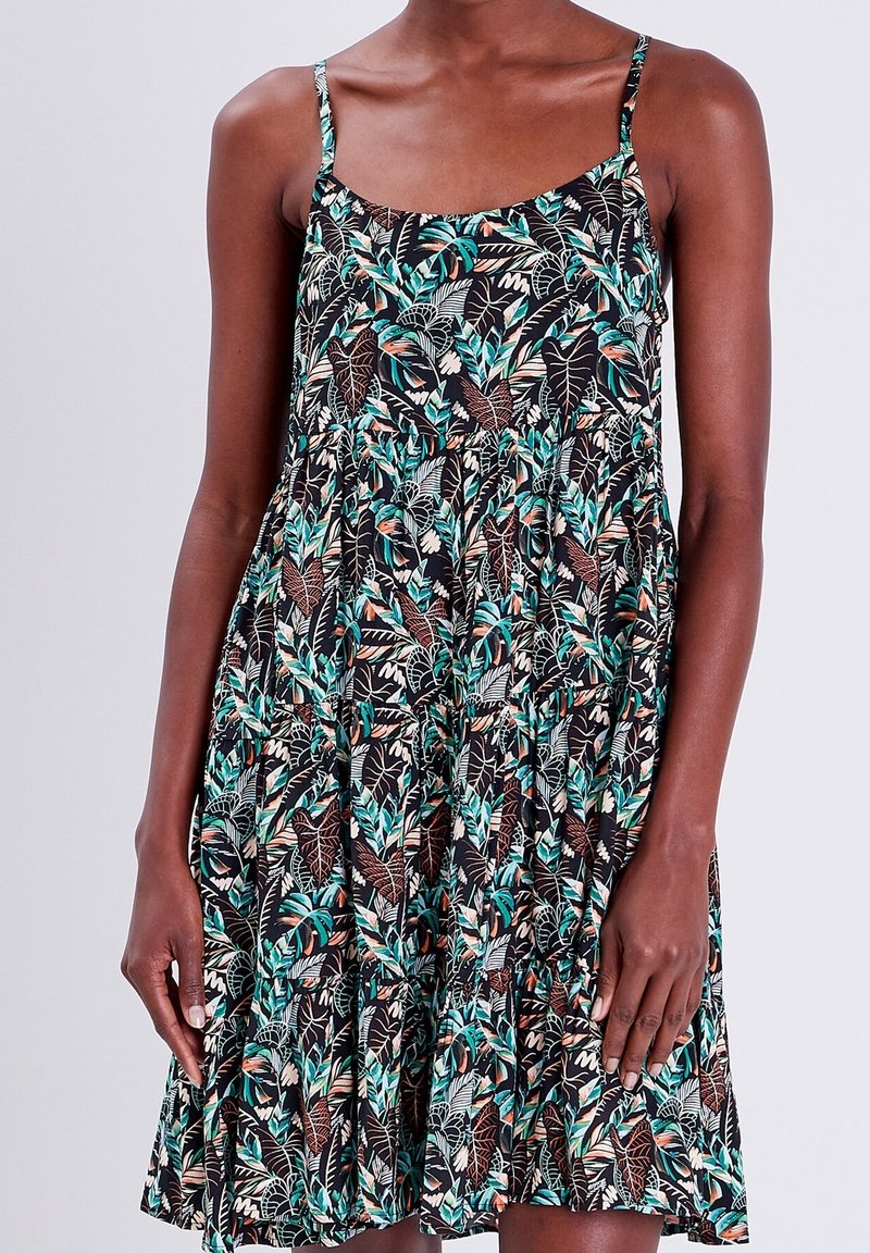Robe noire à bretelles spaghetti réglables, ornée d'un motif de feuilles vertes et brunes, coupe ample et jupe à volants.
