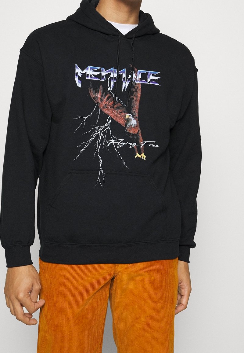 Sudadera negra con un gráfico colorido de un águila, rayos y el texto "Volando Libre". Hecha de material suave y con un bolsillo frontal.