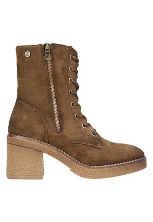 Bottines en suède marron avec un talon épais, présentant un laçage à l'avant, une fermeture éclair sur le côté, et des coutures décoratives le long de la semelle et des accents.