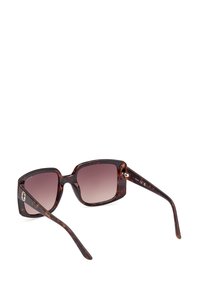 Ochelari de soare pătrați cu un model tartan, lentile cu gradient și accente hardware contrastante. Ramele sunt groase și lucioase.