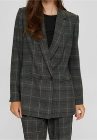 Blazer à carreaux gris avec double rangée de boutons, épaules structurées et deux poches avant. Motif géométrique comprenant des lignes vert foncé et beige.