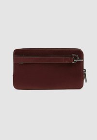 Cartera de cuero burdeos con un acabado suave, cierre de cremallera y una correa lateral. Presenta costuras sutiles y un detalle de hardware plateado.