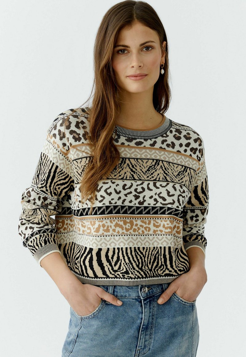 Strickpullover mit Tiermuster in Beige, Schwarz und Creme. Besitzt einen runden Halsausschnitt sowie gerippte Bündchen und Saum. Lässiger Schnitt.