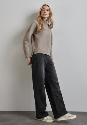 Svetle šedý žebrovaný rolák, černé široké kalhoty a béžové tenisky s akcenty. Slim fit, měkká textura a strukturovaný design.