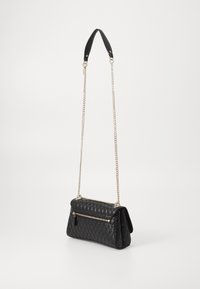 Schwarze gesteppte Handtasche mit einer strukturierten Lederoberfläche, ausgestattet mit einem silbernen Kettenriemen und einer vorderen Reißverschlusstasche.