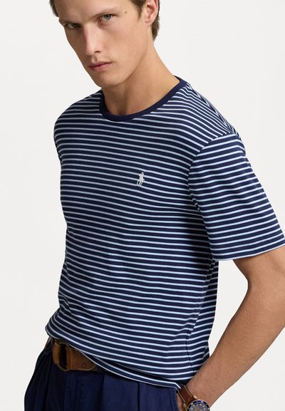 Jūrų ir baltos spalvos juostelėmis marškinėliai su apvaliu kaklu ir trumpomis rankovėmis. Savybė - mažas siuvinėtasis logotipas krūtinėje ir švelni medvilnės tekstūra.