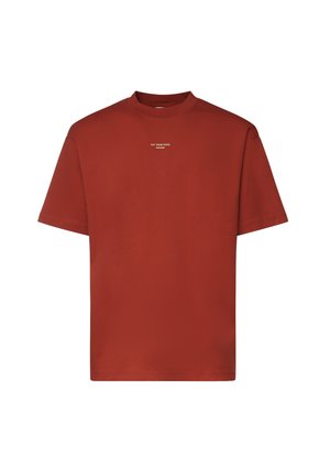 T-shirt a maniche corte color ruggine con piccolo testo bianco "NOT FROM PARIS MADAME" centrato sotto la scollatura davanti.