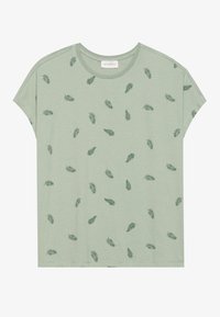 Ljusgrön kortärmad t-shirt i mjukt tyg. Har ett mönster av små, mörkgröna bladtryck över ytan.