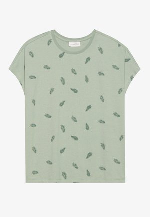 T-shirt à manches courtes de couleur vert clair en tissu doux. Présente un motif de petites impressions de feuilles vert foncé sur toute sa surface.