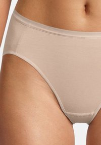 Slip in cotone beige con una texture liscia, design a vita media e elastico in vita. Presenta cuciture minime per un look pulito.