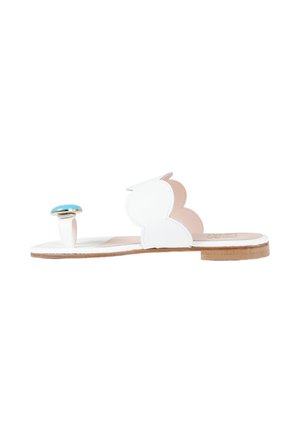 Sandalo bianco piatto con punta aperta, con cinturino smerlato e bottone decorativo turchese sul laccio dell’alluce, visto di lato.