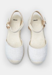 Hvide espadrille sandaler med en tekstureret stofoverdel, åben design og justerbar ankelrem med guldfarvet spænde. Blød indersål.