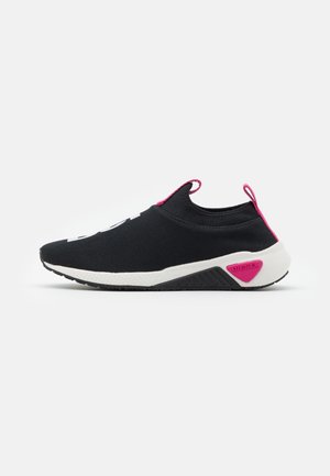 Musta slip-on-tossu valkoisella pohjalla, pinkeillä yksityiskohdilla kantapäässä ja vedinlenkeissä, sekä "DIESEL"-merkintä sivupohjassa.