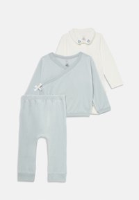 Ensemble pour bébé en deux pièces : haut enveloppant bleu clair avec accent nœud, haut crème à manches longues avec col, et pantalon bleu clair assorti. Matériel en coton doux.