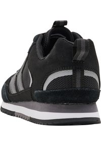 Schwarzer Sportschuh aus einer Mischung aus Wildleder und Mesh-Materialien, mit gepolstertem Schaft, Ziehschlaufe und einem grauen Streifenmuster an der Seite.