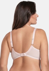 Sujetador rosa hecho de una tela suave, con tirantes ajustables, cierre de gancho y ojal en la parte posterior, y bordes ondulados a lo largo de la banda.