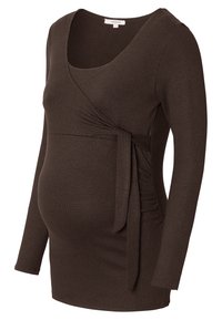 Bruine lange mouw zwangerschapsblouse met een wikkeldesign, strikdetail in de taille en gathered zijkant voor stretch en comfort. Zachte stofstructuur.