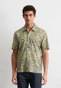 Korte mouwen, groen shirt met bloemenpatroon en zwarte rand, voorzien van een klassieke kraag en knoopsluiting, gemaakt van lichtgewicht stof.
