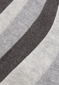 Gestreifter Stoff mit abwechselnden Grautönen und Schwarz, der eine weiche Textur aufweist und ein Strickmuster zeigt, das durch unterschiedlich breite Streifen betont wird.