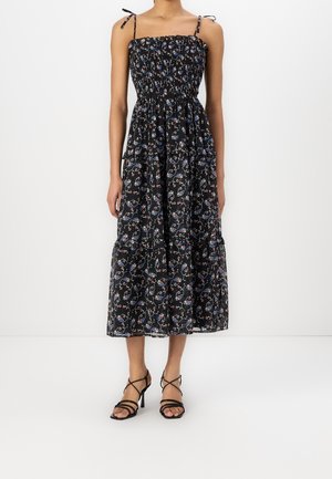 Czarna długa sukienka w kwiaty z marszczonym stanem, regulowanymi ramiączkami i warstwową spódnicą. Charakteryzuje się żywymi niebieskimi i czerwonymi wzorami kwiatowymi.